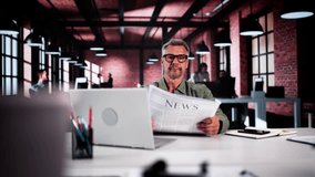 Businessman Reading Newspaper At Office Desk At Work - Powered by Shutterstock - Get 15% off with code: PIKWIZARD15