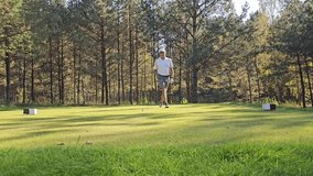Golfer prepares for a tee-off on a lush forested course during a sunny day in autumn - Powered by Shutterstock - Get 15% off with code: PIKWIZARD15