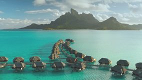 Luxury villas overwater bungalows hotel resort in turquoise water lagoon of Bora Bora tropical island. Mount otemanu in sunset. Remote wild nature paradise, exotic vacation summer travel. Aerial view - Powered by Shutterstock - Get 15% off with code: PIKWIZARD15