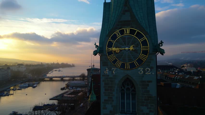 4K Aerial drone footage of Zurich old town during an EPIC morning sunrise. Grossmunster cathedral and Fraumunster Church over the river in Switzerland largest city.