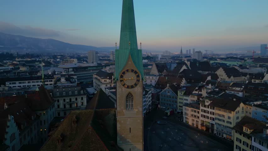 4K Aerial drone footage of Zurich old town during an EPIC morning sunrise. Grossmunster cathedral and Fraumunster Church over the river in Switzerland largest city.