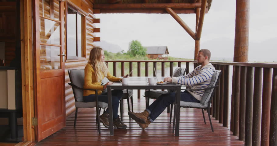 Animation of icons and data processing over biracial couple at table on terrace. Global finance, business, connections, computing and data processing concept digitally generated video.