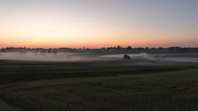 A serene, misty sunrise over a rural landscape with a distant treeline and fog covering the fields - aerial slow - Powered by Shutterstock - Get 15% off with code: PIKWIZARD15