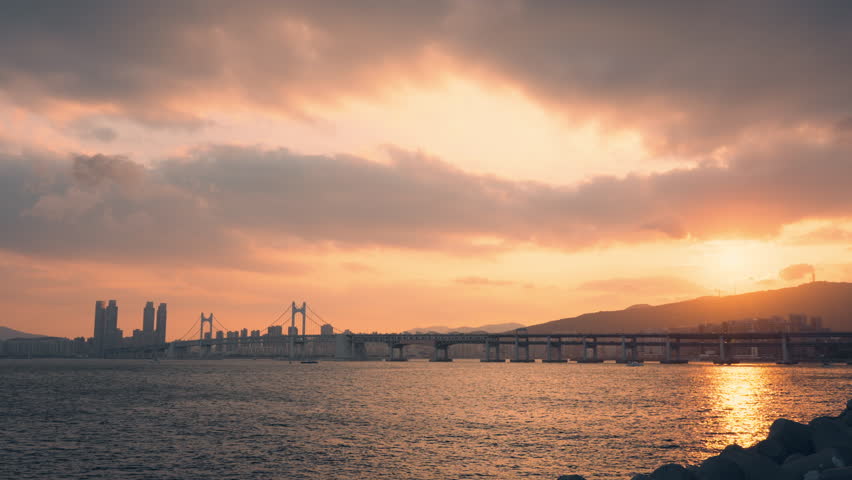 Vivid Pink Sunset with View of Gwangan Bridge or Gwangandaegyo With Dramatic Sky in Busan, Sun Setting Over Mountain
