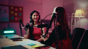 Two asian content creators and influencers engage in a lively podcast recording session within a professional studio, showcasing their dynamic discussion and creativity - Powered by Shutterstock - Get 15% off with code: PIKWIZARD15