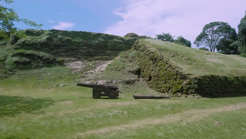 Old canon and old stone wall full of green lichen at the Fuerte de San Lorenzo in the Colon province of Panama. 4k slow motion gimbal shot.