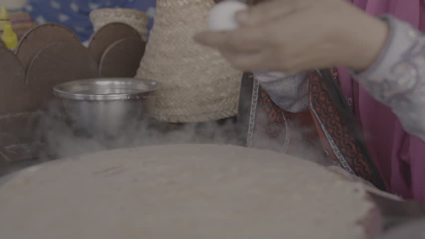 An Omani woman makes Omani bread with eggs