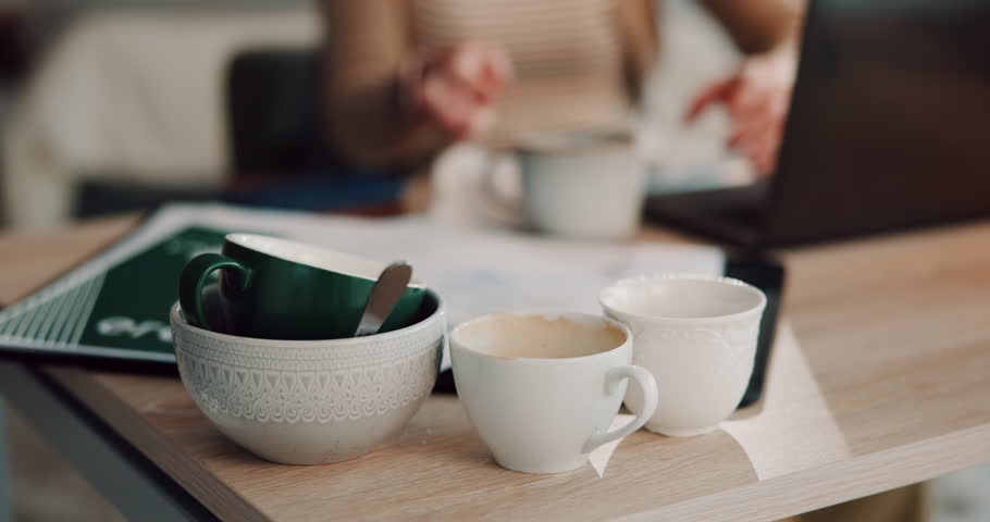 Office, business and empty coffee cups on desk with person drinking for energy on deadline. Hands, table and espresso mugs closeup in pile with tired worker on overtime or overwork on laptop at night