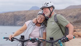 Senior couple riding bikes together in rocky beach enjoying outdoor. Active mature people talking holding mountain bikes. Bicycle lifestyle concept, having fun
 - Powered by Shutterstock - Get 15% off with code: PIKWIZARD15