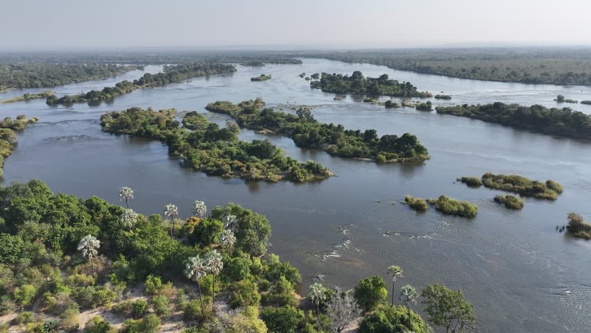 Zimbabwe Skyline At Livingstone Northern Rhodesia Zambia. Powerful Waterfall Cascading Over Rocky Cliff Into Mist. Idyllic Forest Flowing Water Beautiful Day. Flowing Water Travel Landscape.