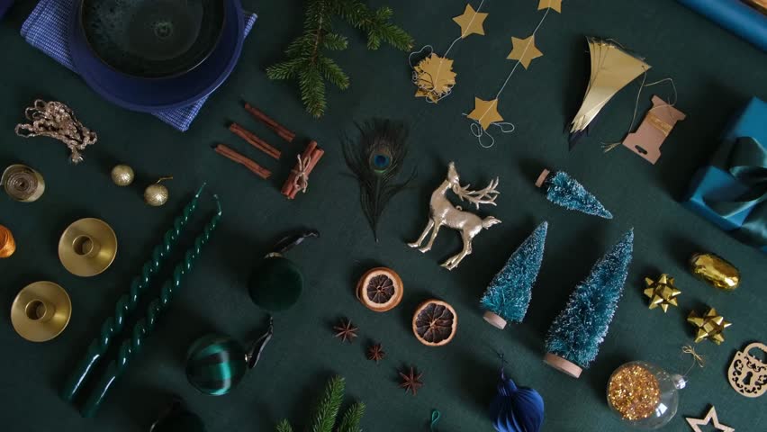 Christmas festive preparation concept on the green linen fabric tablecloth. Xmas objects for table and tree decoration