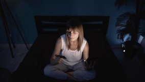 Internet mobile shopping concept. Senior woman using smartphone and credit card purchasing things online sitting in bed a night - Powered by Shutterstock - Get 15% off with code: PIKWIZARD15