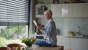 Beautiful woman adjusting smart home settings on touch screen device. Smart home technology for sustainable living. - Powered by Shutterstock - Get 15% off with code: PIKWIZARD15