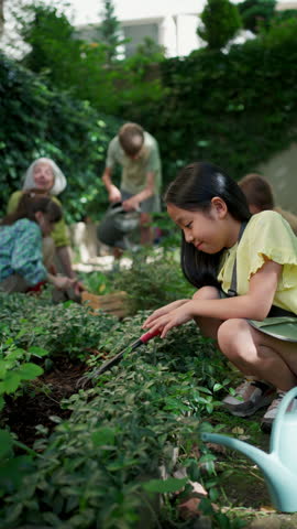 Students and female teacher at outdoor sustainable education class. Kids taking care of plants in school garden. Concept of experiential learning and ecoliteracy.