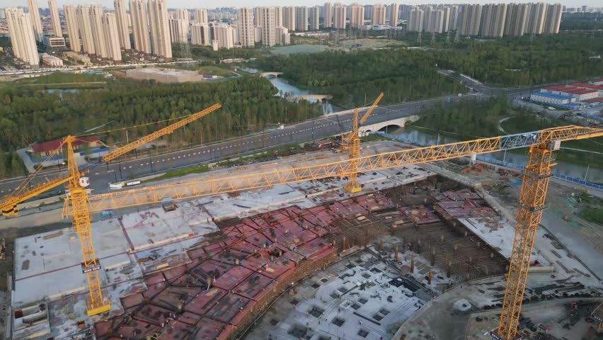 construction site aerial view of yellow crane with modern smart city skyline at distance , urban development 