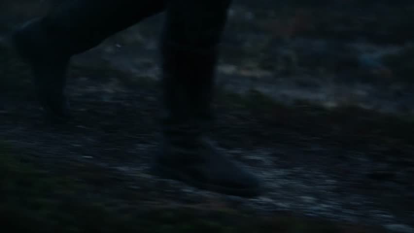 Man foots walking in the forest at evening, fog waving