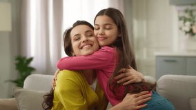 Happy affectionate Caucasian family woman loving female mother adult single parent cuddling embracing hugging little girl child kid daughter smiling laughing sitting indoor cozy sofa living room home - Powered by Shutterstock - Get 15% off with code: PIKWIZARD15