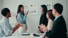 Diverse colleagues celebrate a young businesswoman's success, clapping and praising her achievement in a modern office setting, showcasing teamwork and collaboration - Powered by Shutterstock - Get 15% off with code: PIKWIZARD15