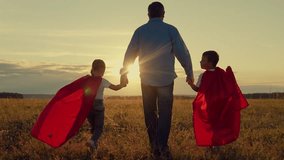 Father daughter, son play superheroes in park. Dad, Super kids dream of becoming superhero, flying in red cape. Dad child go in red raincoats, have fun outdoor. Family Carnival in sun, Halloween, sky - Powered by Shutterstock - Get 15% off with code: PIKWIZARD15