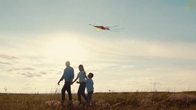 Child to fly kite, sky. Happy family with child in park playing with kite. Young family is playing with kite in meadow. Family walk on grass, child dreams of flying. Dad mom son play travel in nature - Powered by Shutterstock - Get 15% off with code: PIKWIZARD15