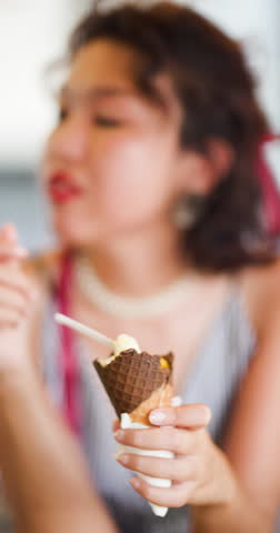 A woman enjoys a delicious cone of ice cream, capturing the essence of a sweet summer treat in a waffle cone.