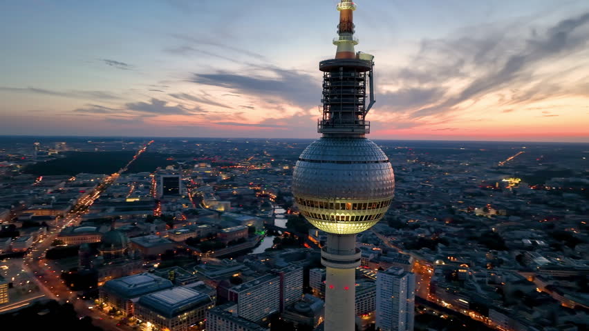 Aerial video shows a vibrant cityscape with a majestic tower famous places architectural landmarks TV Tower, Alexanderplatz at night. Berlin, Germany