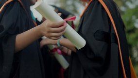 Two women in graduation gowns holding graduation certificates. Scene is celebratory and proud - Powered by Shutterstock - Get 15% off with code: PIKWIZARD15