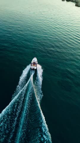 Speedboat crusing drone eye view (sunset)