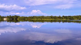 The lake is Mirror like with the reflection of the sky and clouds - Powered by Shutterstock - Get 15% off with code: PIKWIZARD15