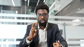 Webcam view. Confident african american businessman in a formal suit talking on a video call looking at the camera in office. Black man communicates at online conference or chats with business partner - Powered by Shutterstock - Get 15% off with code: PIKWIZARD15