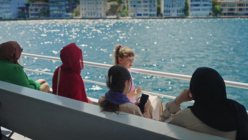 Female Muslim Tourists Sightseeing Istanbul from a Ferry Boat on Sunny Summer Day. Concept of Turkey Travel, Exploring, Vacation, Tourism, Cruise, Discovery, Journey, Enjoying, Holiday