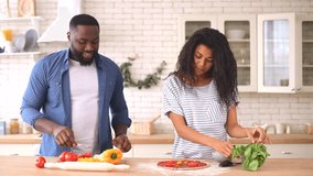 Happy African-American couple in love preparing dinner in the kitchen together, charming young woman and handsome funny guy making pizza and laughing - Powered by Shutterstock - Get 15% off with code: PIKWIZARD15