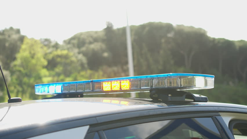 Close-up of flashing yellow and blue lights on a police car, featuring Portuguese police 