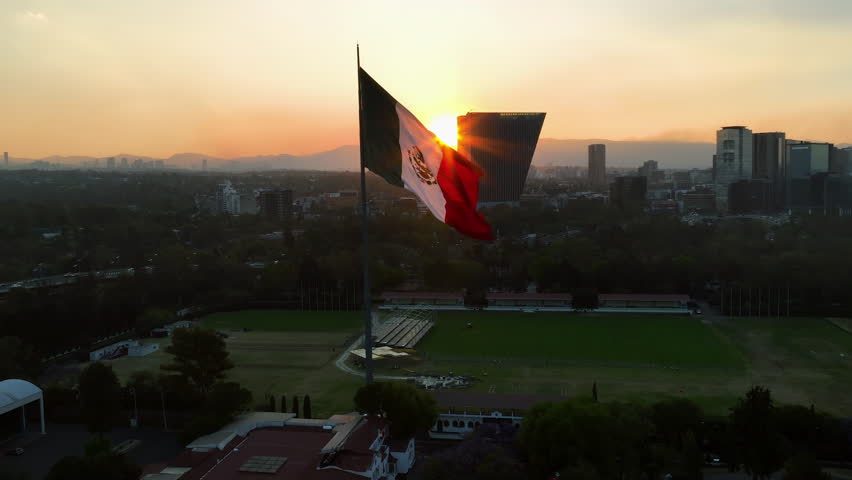 Aerial view around a large mexican flag, sunset in Chapultapec, Mexico city