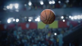 Basketball Ball in flight towards the Winning last Second Score. Ball's Motion Against a Blurred Stadium Backdrop, Championship with Crowd of Cheering Fans. Focus Tracking Shot on the Slow Motion ball - Powered by Shutterstock - Get 15% off with code: PIKWIZARD15