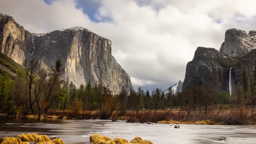 Time Lapse of the the clouds moving over the amazing landscape of Yosemite National Park in California. Merced River in the foreground.