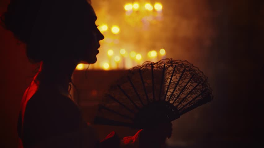 dark shadow silhouette gothic sexy woman holding in hands fan in red light candles flame black night ball room carnival party. baroque dress Mystery lady rococo girl. victorian vampire queen art 4k.