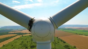 Aerial high angle footage of industrial rope access technician working on a wind turbine generator. Drone shot of skilled professional workers working at high altitude doing repairs of damaged blade. - Powered by Shutterstock - Get 15% off with code: PIKWIZARD15