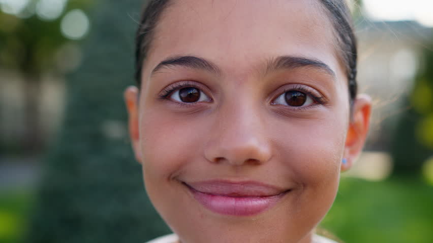 Close up girl little kid child pretty american indian latino student gen z teenager happy smiling face youth orphan teen learner primary school pupil adopted daughter female schoolgirl outdoors city