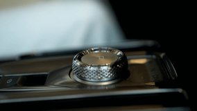 Closeup of sleek automatic gearbox with chrome gear selector in park mode, woman sitting in driver seat changing gear from P gear to R gear using modern rotary knob located on center console. - Powered by Shutterstock - Get 15% off with code: PIKWIZARD15