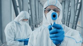 Two healthcare workers in protective gear are taking temperature readings. One is using a digital thermometer, while another is documenting data in a well-lit, contemporary environment. - Powered by Shutterstock - Get 15% off with code: PIKWIZARD15