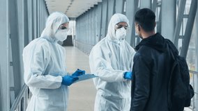 Two medical professionals in protective gear check the temperature of an individual in a healthcare facility, highlighting safety measures during the pandemic. - Powered by Shutterstock - Get 15% off with code: PIKWIZARD15