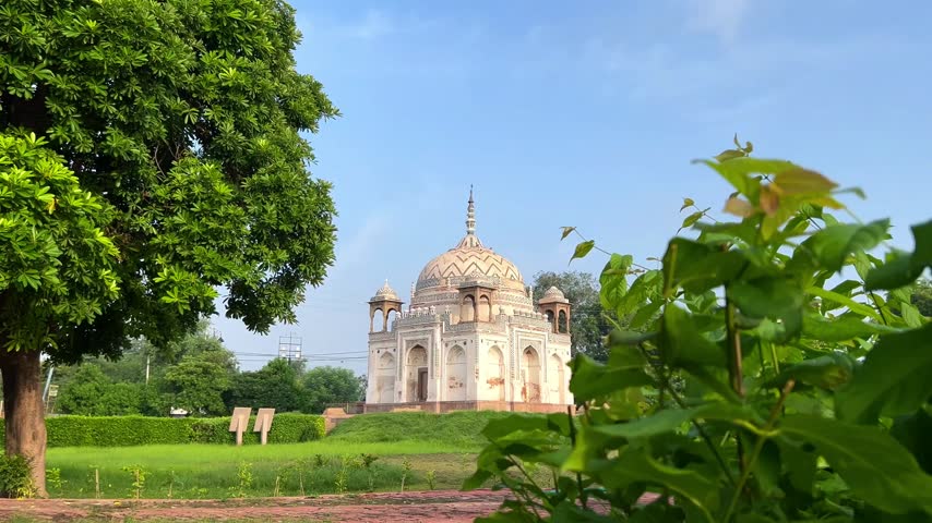 A morning view of an ancient tomb surrounded by lush greenery and trees, radiating peace and beauty with the first light of the day. Tomb of Lal Khan at Varanasi in full of sunny day.