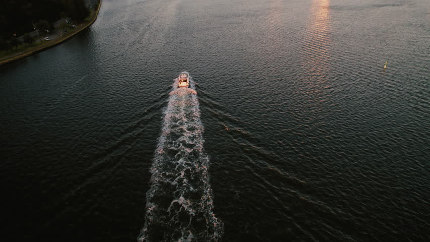 A boat glides through the calm waters of the river at sunset, surrounded by a stunning skyline of Perth, Western Australia that captures the vibrant urban life of the city