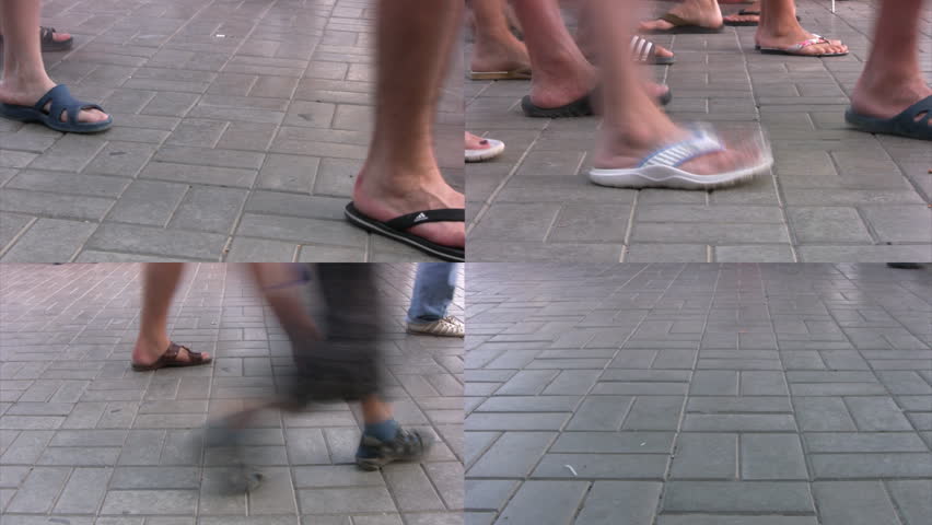 People in the summer shoes walk on a summer promenade. We can see only his legs.