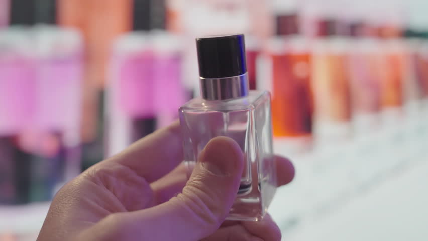 Artisanal Fragrance Exploration: Masculine Hand Evaluating Boutique Perfume. Close-up of Premium 30ml Scent in Upscale Store. Luxury Niche Cologne Selection Experience with Elegant Bottle Display