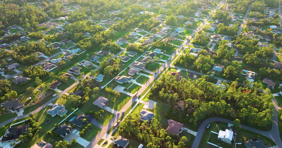 Cars driving on suburban street in Florida small town. American rural landscape with private houses in North Port quiet residential area.