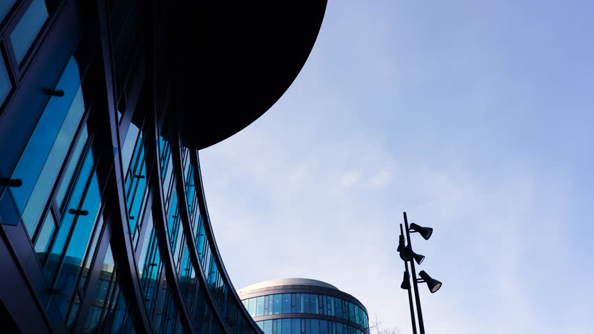 Low angle view of walking near modern glass exterior building, Prague
