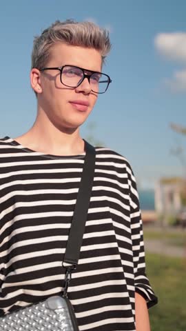 A young man walks along the streets of the city, a sunny evening