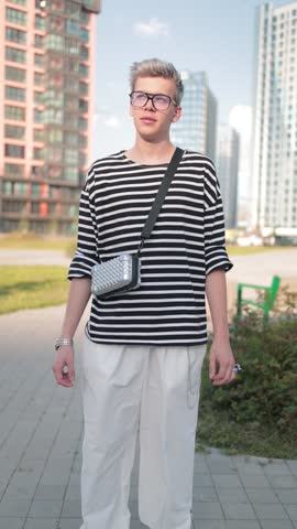 A young man walks along the streets of the city, a sunny evening